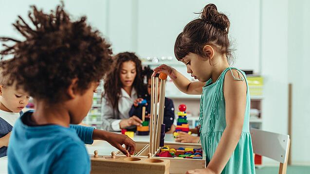 Kinder spielen in einer Kita mit Bauklötzen.