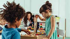 Kinder spielen in einer Kita mit Bauklötzen.