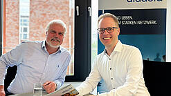 Dr. Hans-Joachim Prinz und Dr. Jens Brandenburg sitzen an einem Tisch.