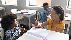 Junge Lehrerin übt mit einem Grundschulkind zählen.