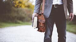 Lehrer auf dem Schulweg mit Umhängetasche.