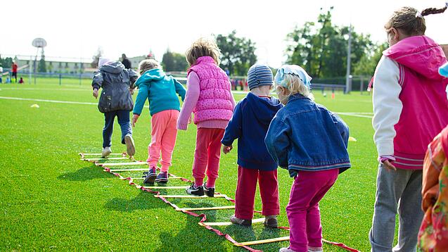 Kinder springen durch einen am Boden liegenden Parcours