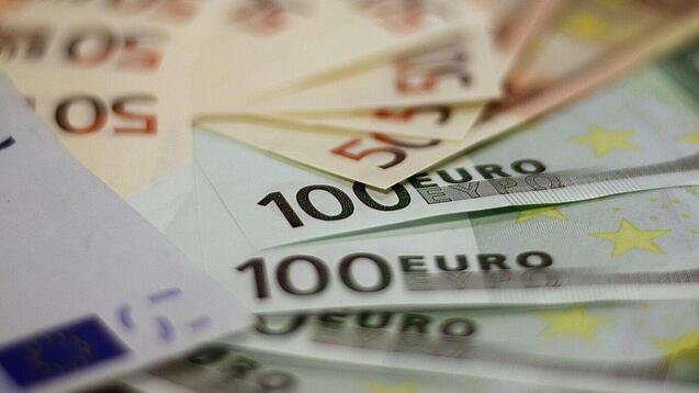 In einem Kreis liegen 100-Euro-, 50-Euro- und 20-Euro-Scheine aufgefächert.