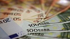 In einem Kreis liegen 100-Euro-, 50-Euro- und 20-Euro-Scheine aufgefächert.