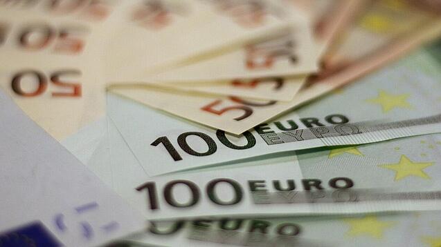 In einem Kreis liegen 100-Euro-, 50-Euro- und 20-Euro-Scheine aufgefächert.