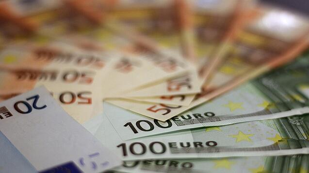 In einem Kreis liegen 100-Euro-, 50-Euro- und 20-Euro-Scheine aufgefächert.