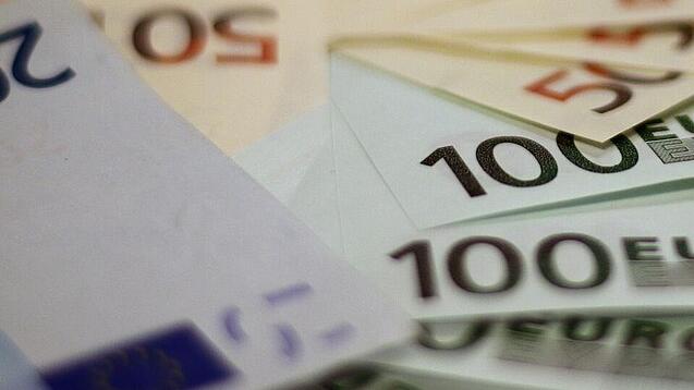 In einem Kreis liegen 100-Euro-, 50-Euro- und 20-Euro-Scheine aufgefächert.