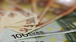 In einem Kreis liegen 100-Euro-, 50-Euro- und 20-Euro-Scheine aufgefächert.