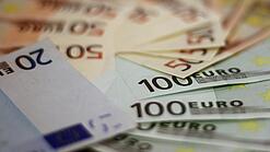 In einem Kreis liegen 100-Euro-, 50-Euro- und 20-Euro-Scheine aufgefächert.