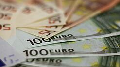 In einem Kreis liegen 100-Euro-, 50-Euro- und 20-Euro-Scheine aufgefächert.
