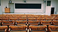 Ein leerer Hörsaal mit Bänken für die Studierenden.