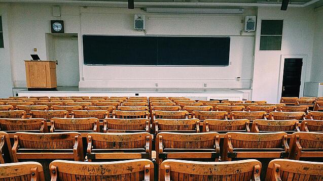 Ein leerer Hörsaal mit Bänken für die Studierenden.