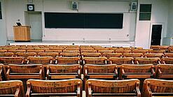 Ein leerer Hörsaal mit Bänken für die Studierenden.