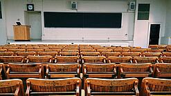Ein leerer Hörsaal mit Bänken für die Studierenden.