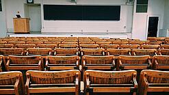 Ein leerer Hörsaal mit Bänken für die Studierenden.