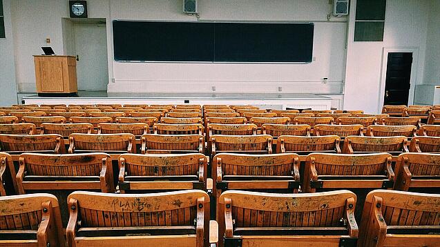Ein leerer Hörsaal mit Bänken für die Studierenden.