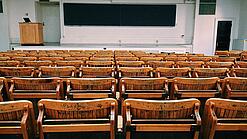 Ein leerer Hörsaal mit Bänken für die Studierenden.