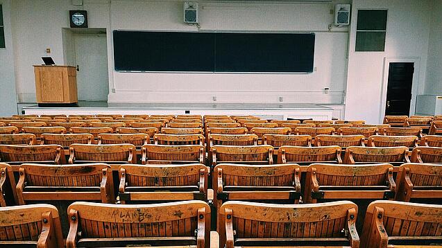Ein leerer Hörsaal mit Bänken für die Studierenden.