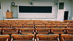 Ein leerer Hörsaal mit Bänken für die Studierenden.