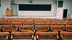 Ein leerer Hörsaal mit Bänken für die Studierenden.