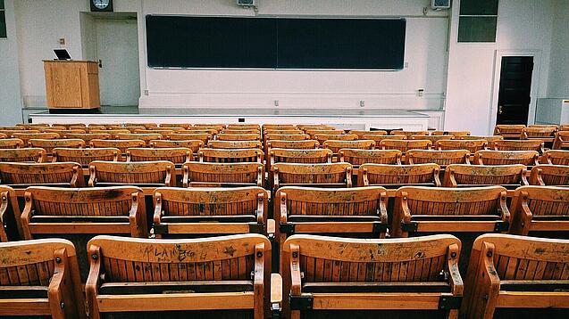 Ein leerer Hörsaal mit Bänken für die Studierenden.