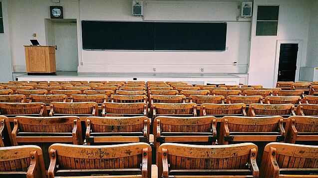 Ein leerer Hörsaal mit Bänken für die Studierenden.