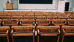 Ein leerer Hörsaal mit Bänken für die Studierenden.