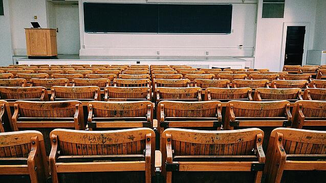 Ein leerer Hörsaal mit Bänken für die Studierenden.