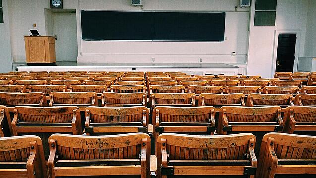 Ein leerer Hörsaal mit Bänken für die Studierenden.
