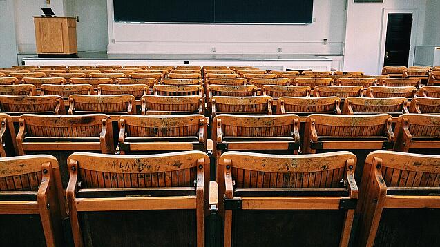 Ein leerer Hörsaal mit Bänken für die Studierenden.
