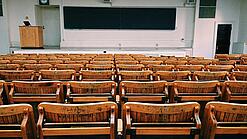 Ein leerer Hörsaal mit Bänken für die Studierenden.