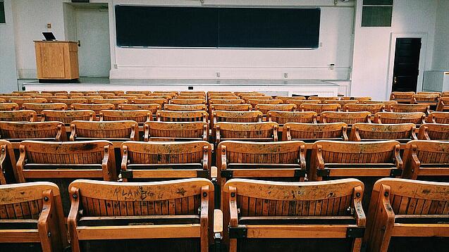 Ein leerer Hörsaal mit Bänken für die Studierenden.