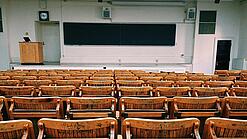 Ein leerer Hörsaal mit Bänken für die Studierenden.
