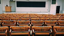 Ein leerer Hörsaal mit Bänken für die Studierenden.