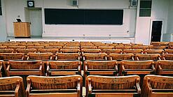 Ein leerer Hörsaal mit Bänken für die Studierenden.