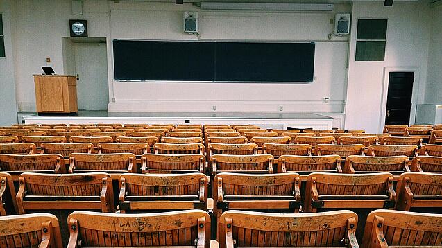 Ein leerer Hörsaal mit Bänken für die Studierenden.