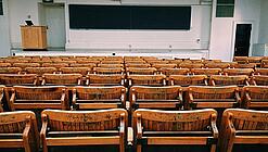 Ein leerer Hörsaal mit Bänken für die Studierenden.