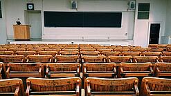 Ein leerer Hörsaal mit Bänken für die Studierenden.