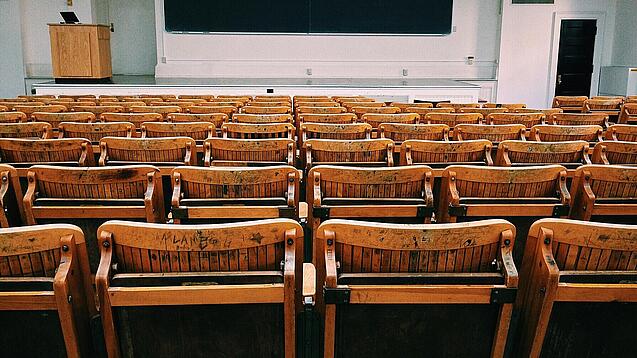 Ein leerer Hörsaal mit Bänken für die Studierenden.