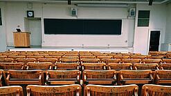 Ein leerer Hörsaal mit Bänken für die Studierenden.