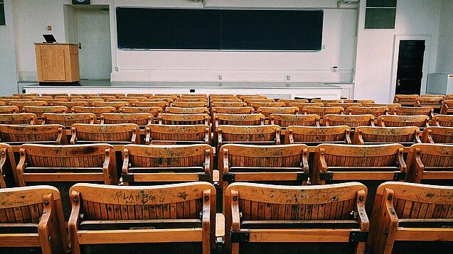Ein leerer Hörsaal mit Bänken für die Studierenden.