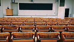 Ein leerer Hörsaal mit Bänken für die Studierenden.