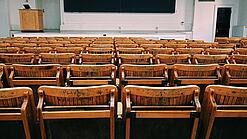 Ein leerer Hörsaal mit Bänken für die Studierenden.