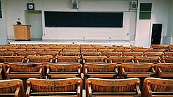 Ein leerer Hörsaal mit Bänken für die Studierenden.