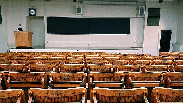Ein leerer Hörsaal mit Bänken für die Studierenden.
