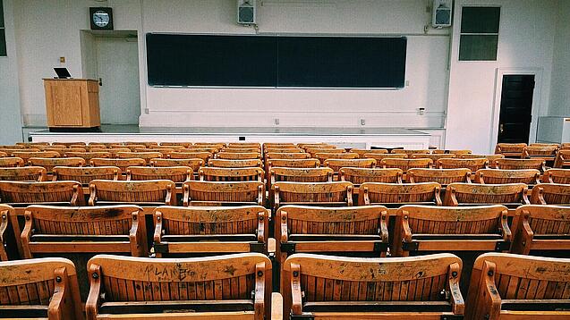 Ein leerer Hörsaal mit Bänken für die Studierenden.