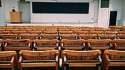 Ein leerer Hörsaal mit Bänken für die Studierenden.