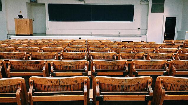 Ein leerer Hörsaal mit Bänken für die Studierenden.
