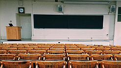 Ein leerer Hörsaal mit Bänken für die Studierenden.
