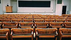 Ein leerer Hörsaal mit Bänken für die Studierenden.